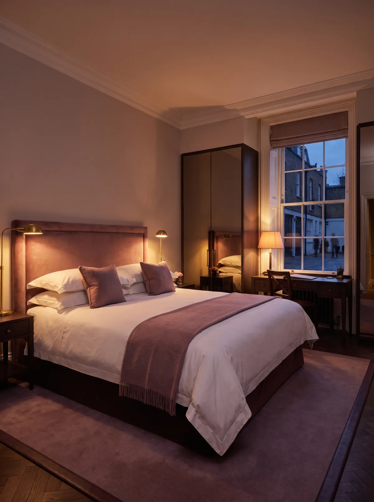 The Mews Room: a king bed with a dusty-rose velvet headboard beside a sash window onto a cobbled mews